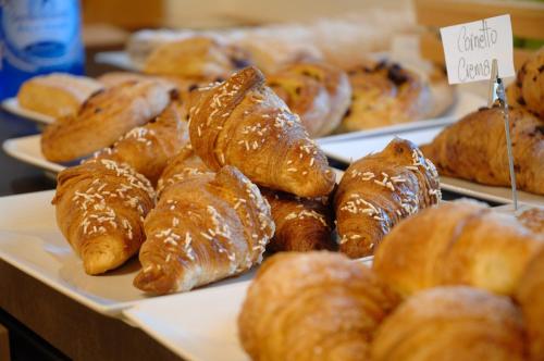 a bunch of croissants and other pastries on plates at Residence Hotel Miralago in Pergine Valsugana