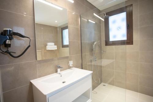 a bathroom with a sink and a shower and a mirror at The Hawana Pearl لؤلؤة هوانا in Salalah