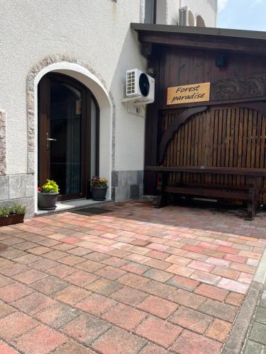 a bench sitting outside of a building next to a door at Apartment & Studio Forest Paradise in Cerkno
