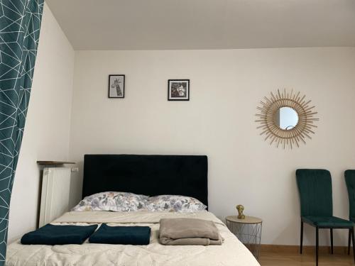 a bedroom with a bed with a mirror and two chairs at Magnifique appartement Metz centre in Metz