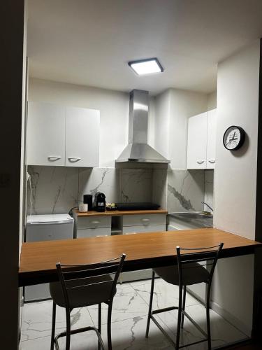 une cuisine avec une table en bois et deux chaises dans l'établissement Magnifique appartement Metz centre, à Metz