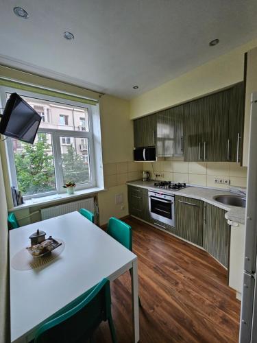 a kitchen with a white table and a table and chairs at Liepu gatve in Klaipėda