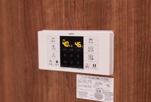 an electronic clock is on a wooden wall at SATELLITE HOTEL Roppongi サテライトホテル六本木 in Tokyo
