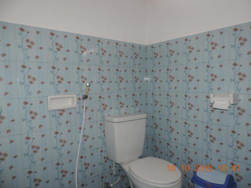 a bathroom with a toilet and flowers on the wall at Yaya Bungalows Blue Coral in Gili Meno