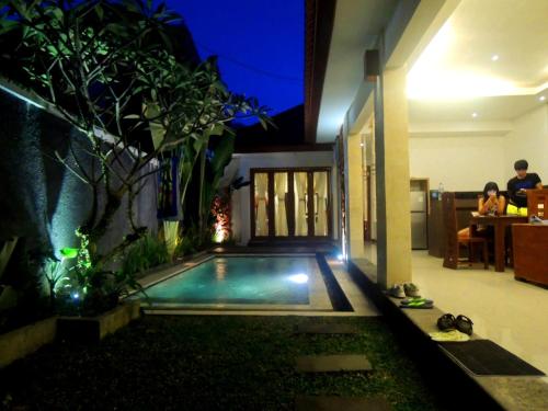 a swimming pool in the middle of a house at Jayastuti House in Ubud