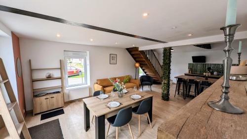 un salon avec une table et une salle à manger dans l'établissement Maison conviviale lac & jardin, à Mesnil-Saint-Père