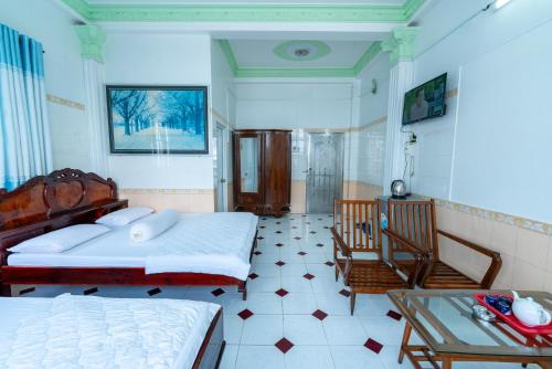 a bedroom with two beds and a glass table at Thien Thanh Hotel in Vĩnh Long