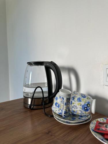 a coffee pot and a cup on a wooden table at Orenda in Tʼelavi