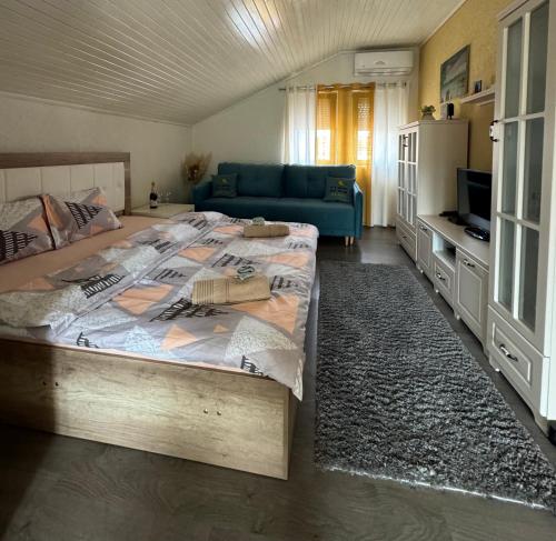 a bedroom with a large bed and a blue couch at Villa Ristovski in Ohrid