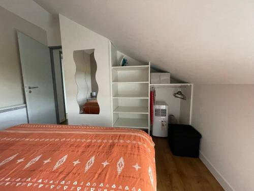 an attic room with a bed and a staircase at Maison de 2 chambres proche A11 Ancenis, Logis du Château Rouge in Mésanger