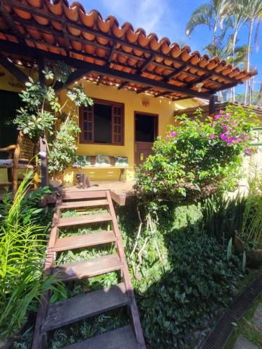 a garden with a wooden ladder in front of a house at Pousada Cachoeira in Abraão