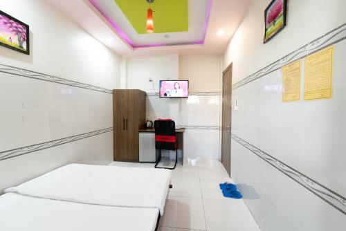 a room with a bed and a desk and a tv at Thien Thanh Hotel in Vĩnh Long