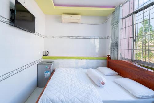 a small bedroom with a bed and a window at Thien Thanh Hotel in Vĩnh Long
