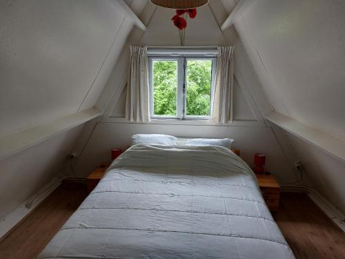 a bed in a room with a window at Het vlindertje in Durbuy