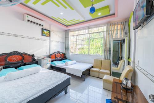 a bedroom with two beds and a table and chairs at Thien Thanh Hotel in Vĩnh Long