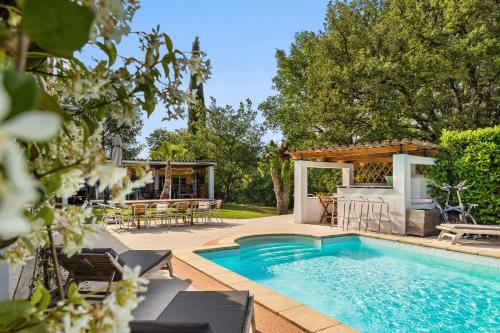 une piscine avec une table et des chaises ainsi qu'une maison dans l'établissement Villa & Loft climatisés,piscine privée chaufffée, Fitness,proche Cannes, Grasse, à Montauroux