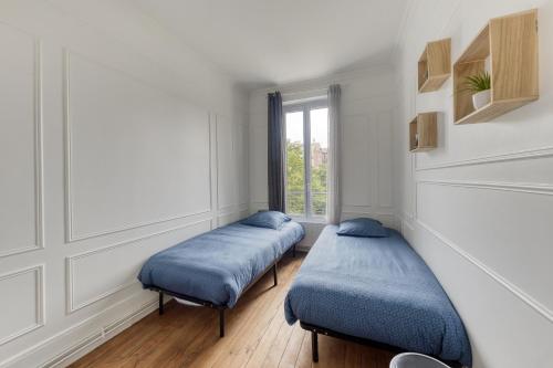zwei Betten in einem Zimmer mit Fenster in der Unterkunft Coup de cœur parisien à 15 mn de Paris - 45 mn Disney in Noisy-le-Sec