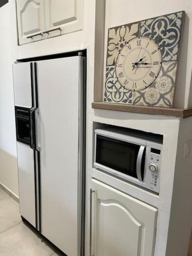 - un réfrigérateur blanc avec une horloge au-dessus dans l'établissement Résidence Cannes Plage Business Saisonnier, à Cannes