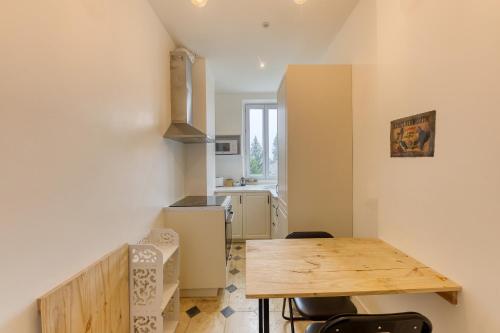 eine Küche mit einem Holztisch in einem Zimmer in der Unterkunft Coup de cœur parisien à 15 mn de Paris - 45 mn Disney in Noisy-le-Sec