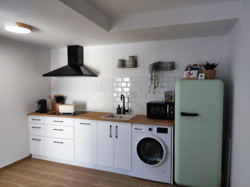 a kitchen with a refrigerator and a washing machine at Apartamentos La Casa del Maestro in Alhama de Aragón