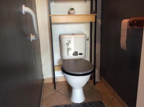 un water bianco con un sedile nero in un bagno di LeuQuinze a Saint-Leu