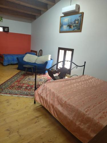 a bedroom with a bed and a couch in a room at Segesta Antichi Sapori in Calatafimi