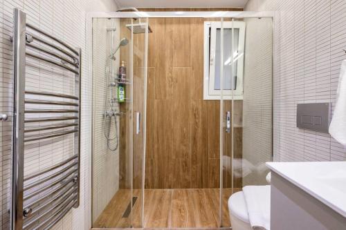 y baño con ducha y puerta de cristal. en Athenian Riviera Beach Apartment, en Atenas