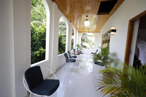 a hallway with chairs and tables and windows at Sunflowers Canada House in Jaffna