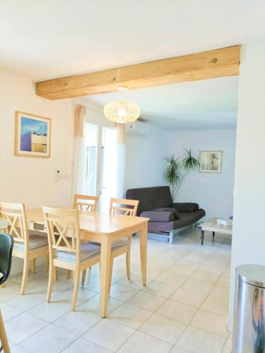 un salon avec une table et des chaises en bois dans l'établissement Rez de villa au calme proche de la plage, à Fréjus