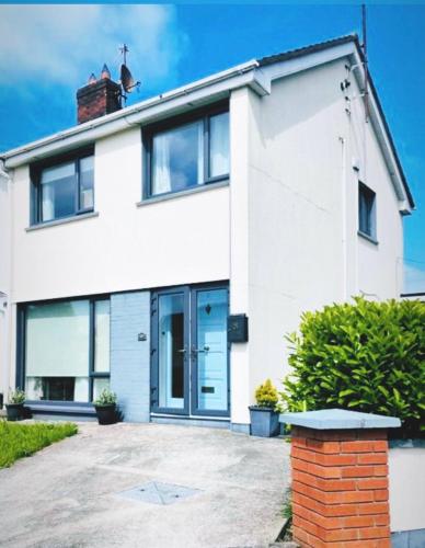 a white house with a driveway in front of it at Elena Retreats in Drogheda