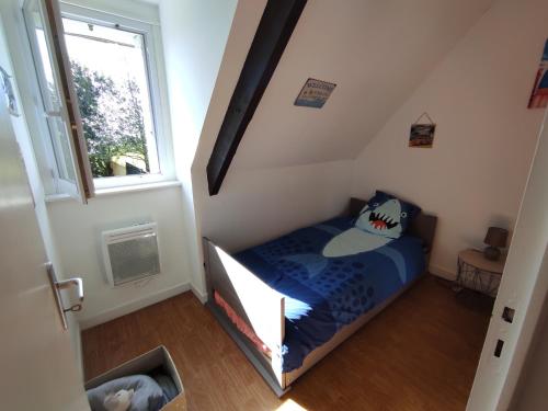 une petite chambre avec un lit dans un grenier dans l'établissement Les petits Embruns, à Moëlan-sur-Mer