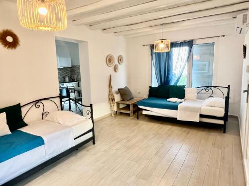 1 dormitorio con 2 camas y mesa en Vaqueros, en Mykonos ciudad