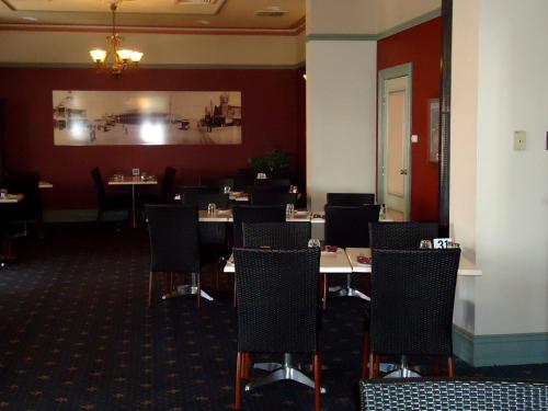 a dining room with tables and chairs at The Palace Hotel Kalgoorlie in Kalgoorlie