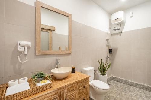 a bathroom with a sink and a toilet and a mirror at ☆ Villa Larissa ☆ Seminyak 2BR Pool Kuta Petitenget in Seminyak