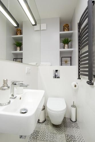 a white bathroom with a sink and a toilet at Old Town Residence at Topolowa in Krakow