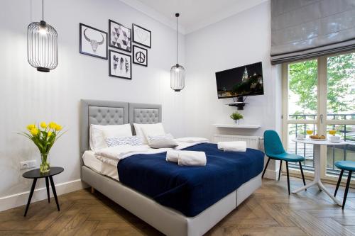 a bedroom with a bed and a tv and a table at Old Town Residence at Topolowa in Krakow