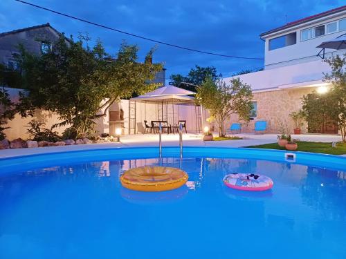 a large swimming pool with a table in a backyard at Apartments Villa Mihaela in Banj