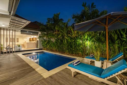an outdoor pool with chairs and an umbrella at ☆ Villa Larissa ☆ Seminyak 2BR Pool Kuta Petitenget in Seminyak