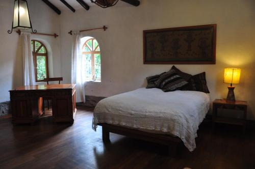 - une chambre avec un lit, un bureau et une fenêtre dans l'établissement Valle Dorado Lodge, à Cusco