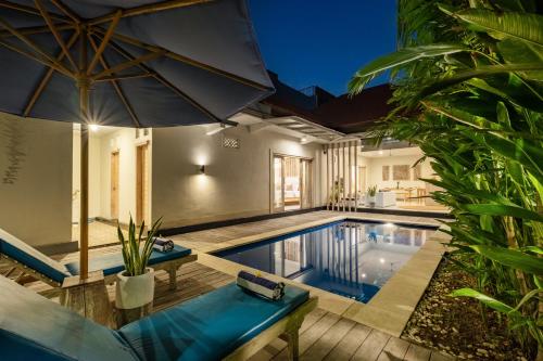 a swimming pool with an umbrella in a villa at ☆ Villa Larissa ☆ Seminyak 2BR Pool Kuta Petitenget in Seminyak