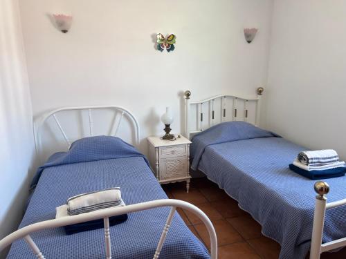 two beds in a small room with blue sheets at Casa da avó Delmira in São Marcos da Serra