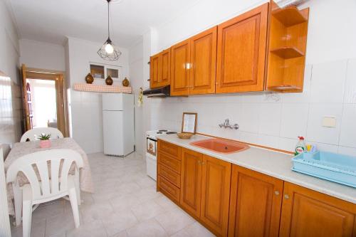 a kitchen with wooden cabinets and a table and a sink at Diavlos Oreon in Oreoi