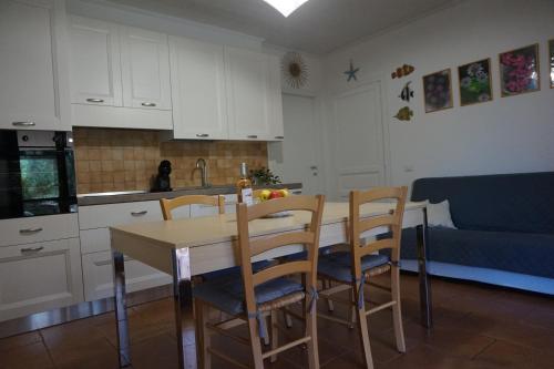 a kitchen with a table and chairs and a couch at Rosanna House in Bombarde Beach in Alghero