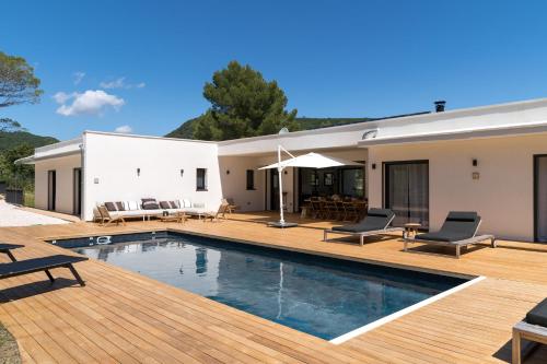 une maison avec une piscine et une terrasse en bois dans l'établissement Les Roches Blanches-Montferrat, à Montferrat