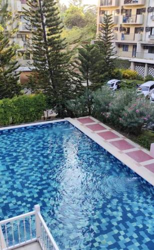 a large blue swimming pool in front of a building at Stylish Studio in Downtown with Remote Work Setup in Cabaguio