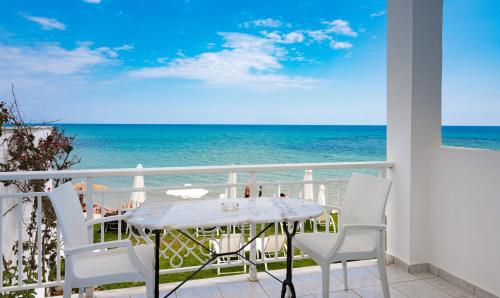 a table and chairs on a balcony overlooking the ocean at Filoxenia Beach in Tsilivi
