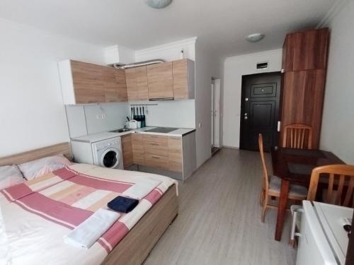 a small bedroom with a bed and a kitchen at Apartments Sarafovo in Burgas City