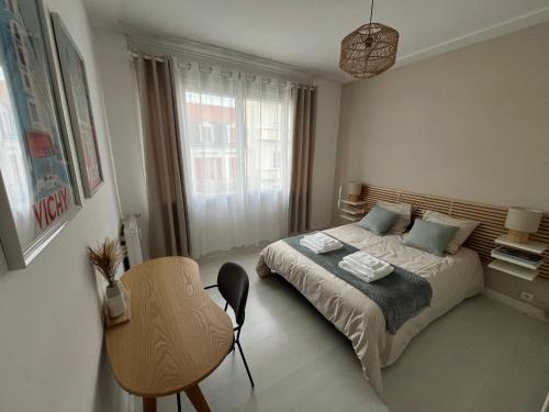 une chambre avec un lit, une chaise et une fenêtre dans l'établissement Appartement Vichy Centre, à Vichy