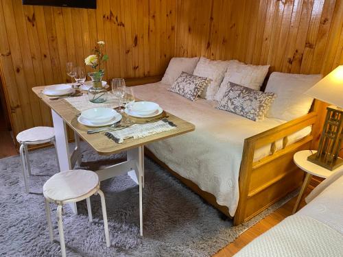 a bedroom with a bed with a table and chairs at Vista al volcán con tinaja y río en Conguillío in Curacautín