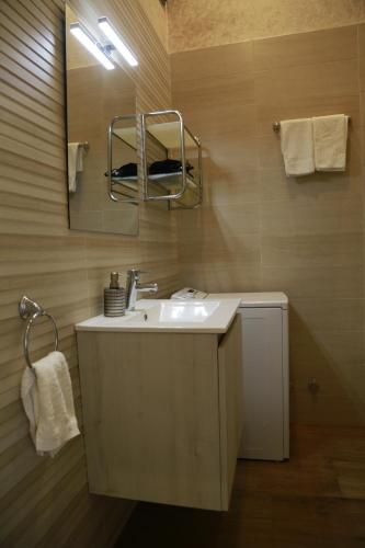 a bathroom with a sink and a mirror at Apartamentos La Arena in Miengo